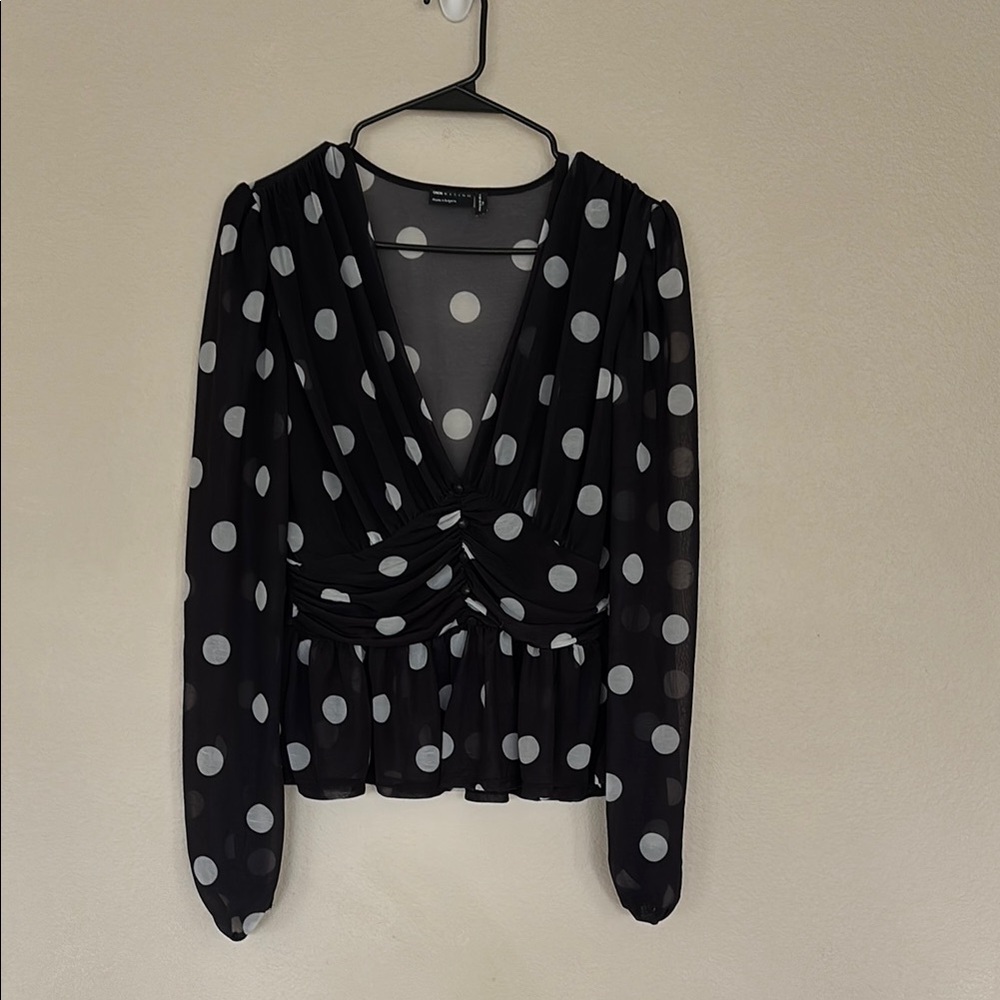 Black wrap blouse with plunge neckline puff sleeves and peplum style